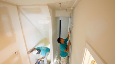Professional painting service painting an interior room in a client’s house