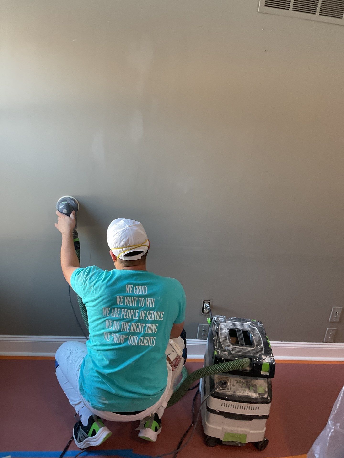 Professional interior painter sanding and preparing walls during a wallpaper removal and painting project in Yardley, PA