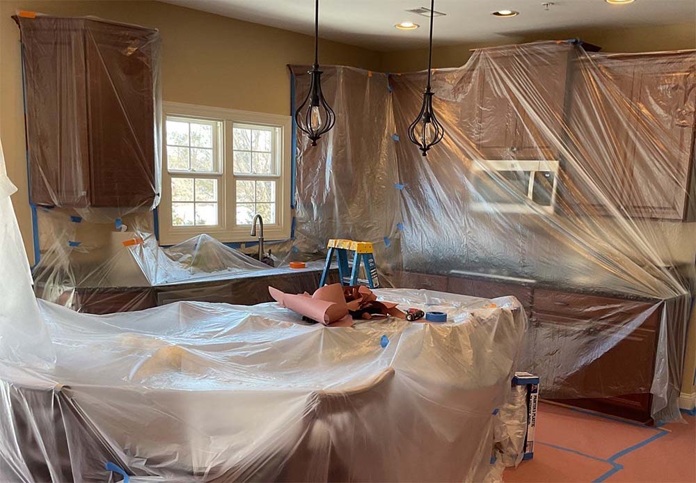 Kitchen cabinets and countertops covered before interior painting in Lower Bucks County