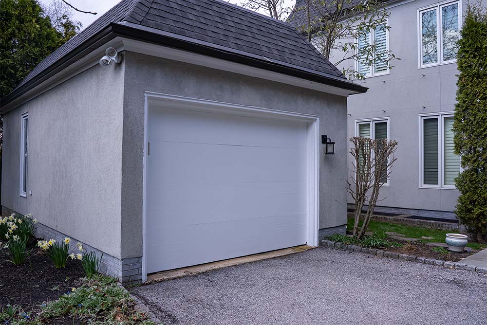 Garage exterior painting project in Philadelphia PA featuring freshly painted stucco walls and white garage door by Groovy Hues Painting of Philadelphia