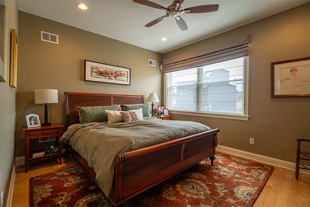 Bedroom interior painting project in Philadelphia PA with warm neutral wall colors, white trim, and professionally painted finishes by Groovy Hues Painting of Philadelphia